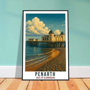 May include: A framed art print featuring Penarth Pier in Vale of Glamorgan. The artwork depicts a pier extending into the sea under a cloudy sky. The pier is a light yellow color, and the text "PENARTH" is displayed at the bottom of the print.