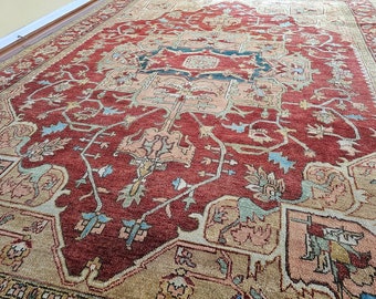 May include: A red, beige, and blue patterned rug with intricate designs. The rug has a traditional Persian style.