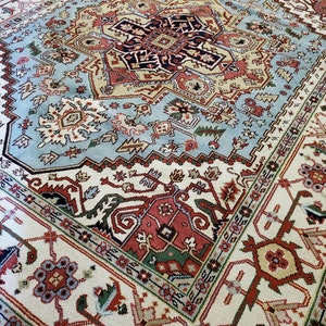 May include: A traditional Persian rug with a blue, red, and white color scheme. The rug features intricate floral and geometric patterns.