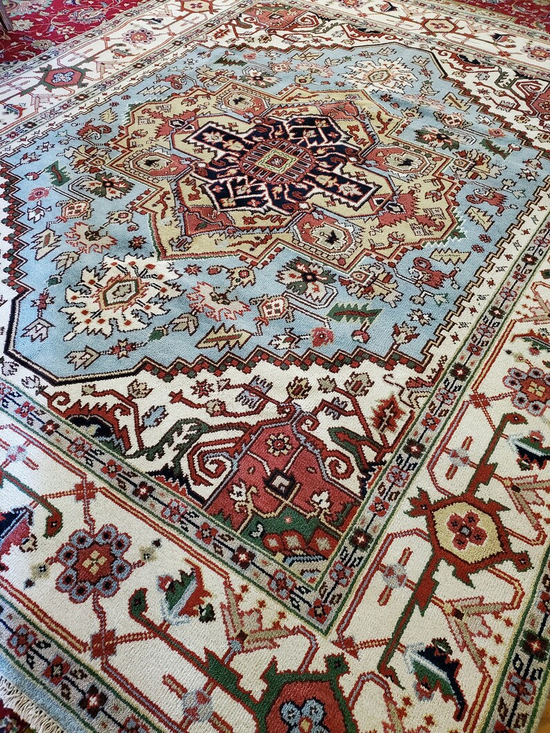 May include: A traditional Persian rug with a blue, red, and white color scheme. The rug features intricate floral and geometric patterns.
