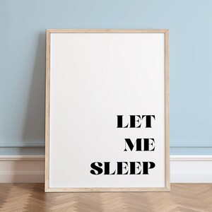 May include: A framed print with the text "LET ME SLEEP" in black bold letters on a white background.