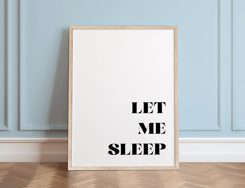 May include: A framed print with the text "LET ME SLEEP" in black bold letters on a white background.