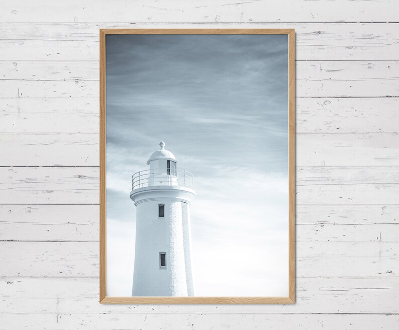 Pu&ograve; includere: Una fotografia in bianco e nero di un faro bianco contro un cielo nuvoloso.