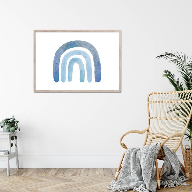 May include: A framed watercolor painting of a blue rainbow on a white background. The rainbow is made up of four arches, with the top arch being the darkest blue and the bottom arch being the lightest blue. The rainbow is centered in the frame.