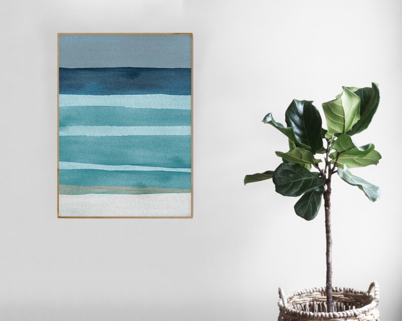 May include: A framed abstract watercolor painting with horizontal stripes in shades of blue and green. The painting is on a white wall with a potted plant in the foreground.