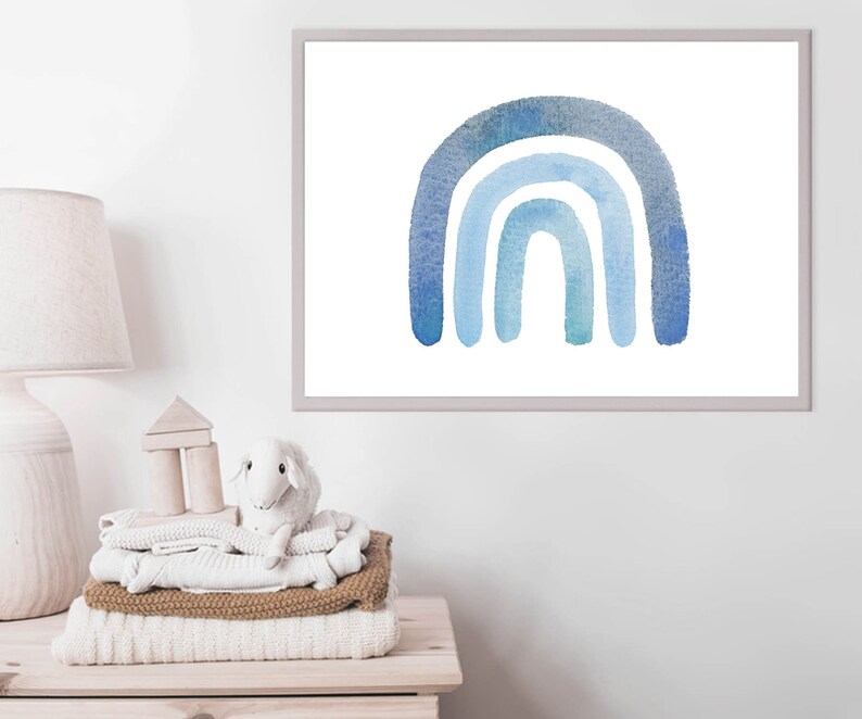 May include: A watercolor painting of a blue rainbow with four arches. The rainbow is painted on a white background and framed in a simple gray frame.