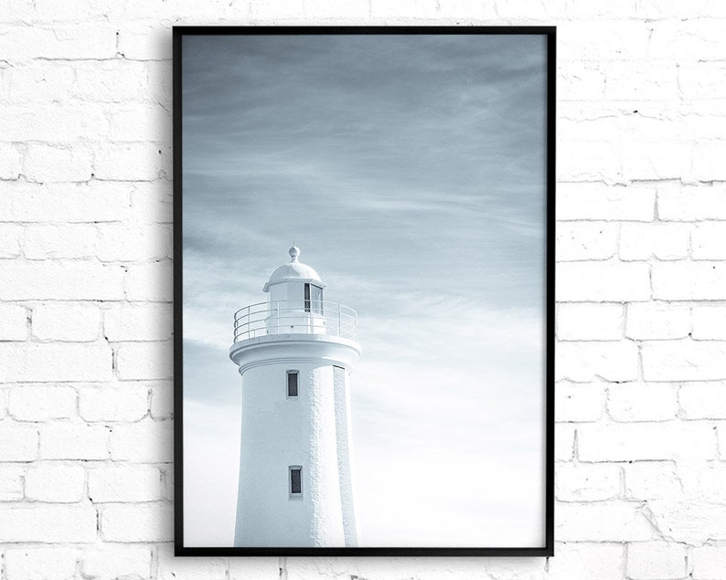 Pu&ograve; includere: Una fotografia in bianco e nero di un faro bianco contro un cielo nuvoloso.
