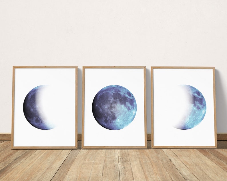 May include: Three framed prints of a blue moon in different phases. The moon is a watercolor style illustration with a white background.