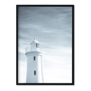 Pu&ograve; includere: Un faro bianco con una ringhiera nera si erge alto contro un cielo nuvoloso e blu. Il faro &egrave; un design architettonico classico con una cima arrotondata e una serie di finestre.