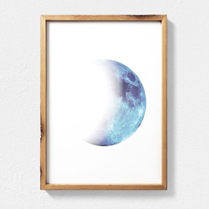 May include: A framed print of a blue and white crescent moon on a white background.