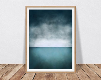 May include: A framed abstract painting of a dark blue sky with white clouds above a dark blue ocean. The painting is in a light wood frame.