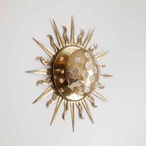 以下が含まれることがあります： クリスタルで飾られた三日月模様の金色の太陽の形をした壁掛け照明