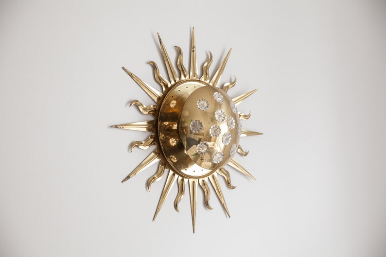 以下が含まれることがあります： クリスタルで飾られた三日月模様の金色の太陽の形をした壁掛け照明
