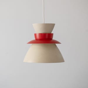 May include: A white and red layered pendant light fixture with a white cord.