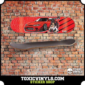 Könnte beinhalten: Ein rotes und schwarzes Skateboard-Deck mit einem Grafikdruck eines roten Autos und einer Comic-Frau. Der Text "Street Legal" ist auf dem Deck aufgedruckt. Das Skateboard ist an einer Backsteinwand montiert.