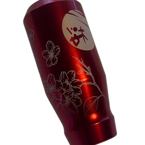 Pu&ograve; includere: Pomello del cambio in alluminio rosso con un design inciso bianco di fiori di ciliegio e un cerchio con caratteri giapponesi.