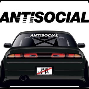 Puede incluir: Coche negro con una pegatina en la luneta trasera que dice "ANTI SOCIAL" y una matrícula que dice "S-14".