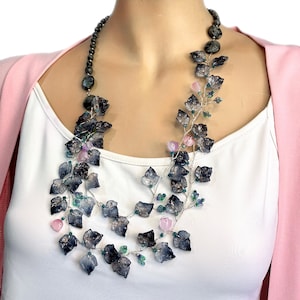Collar babero con hojas y flores. Joya llamativa en gris y rosa.