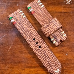 Puede incluir: Dos correas de reloj de cuero marr&oacute;n con costuras blancas y detalles de hilo de colores. Las correas tienen una superficie texturizada y est&aacute;n dise&ntilde;adas para relojes de pulsera.