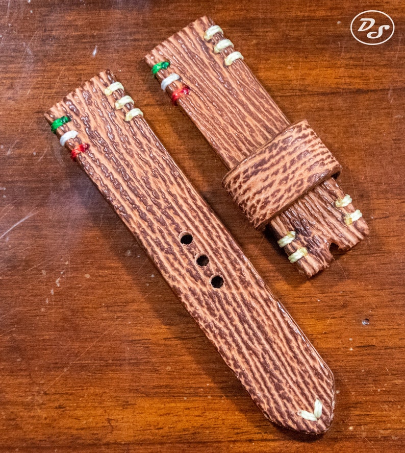 Puede incluir: Dos correas de reloj de cuero marr&oacute;n con costuras blancas y detalles de hilo de colores. Las correas tienen una superficie texturizada y est&aacute;n dise&ntilde;adas para relojes de pulsera.