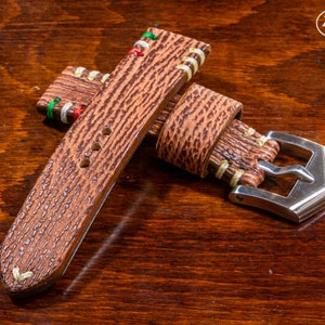 Puede incluir: Una correa de reloj de cuero marr&oacute;n con costuras de colores y una hebilla plateada. La correa tiene una superficie texturizada y est&aacute; dise&ntilde;ada para un reloj de pulsera.