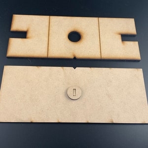以下が含まれることがあります： 未完成の木材の2つの部分。1つは丸い穴と2つの長方形の切り抜きがあり、もう1つは長方形の切り抜きが1つあります。これらの部分は組み合わせて使用​​するように設計されています。