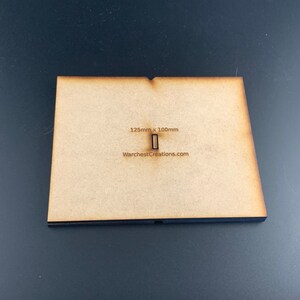 以下が含まれることがあります： 125mm x 100mm の長方形の切り抜きが施された茶色の木製ベース。ベースには「WarchestCreations.com」のラベルが貼られています。