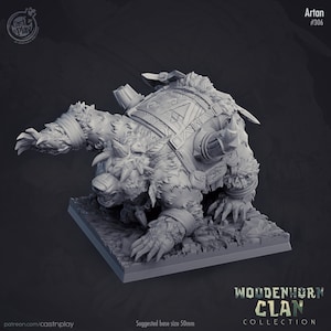 Puede incluir: Una miniatura gris y detallada de una criatura parecida a un oso con un casco con cuernos y una mochila. La criatura está en posición de cuclillas con las garras extendidas. La miniatura forma parte de la colección Woodenhorn Clan.