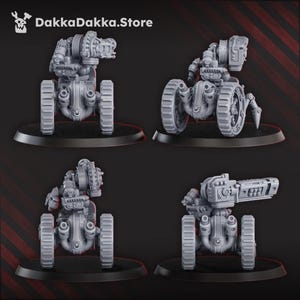Puede incluir: Se muestran cuatro máquinas de guerra en miniatura grises con ruedas grandes y componentes mecánicos detallados. Cada una está montada sobre una base negra. El texto "DakkaDakka.Store" es visible en la esquina superior izquierda.