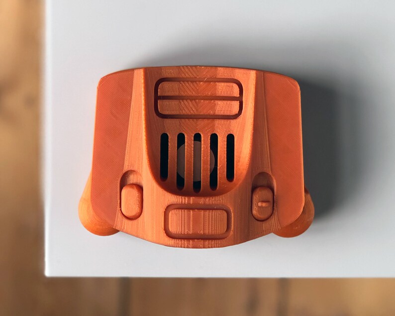 May include: An orange 3D printed model of a Nintendo 64 console.