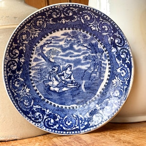 Plato antiguo de loza de Staffordshire con decoración azul transferida, diseño de amor y cortejo.