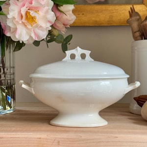 Puede incluir: Plato de servir de porcelana blanca con tapa y dos asas. El plato tiene un diseño clásico y es perfecto para servir una variedad de alimentos.