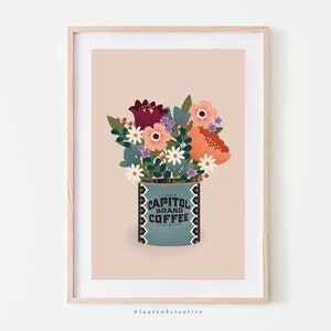 May include: A framed print of a vintage coffee can with a bouquet of flowers in it. The can is blue with white lettering that says "Capitol Brand Coffee". The flowers are red, orange, pink, white, and purple.