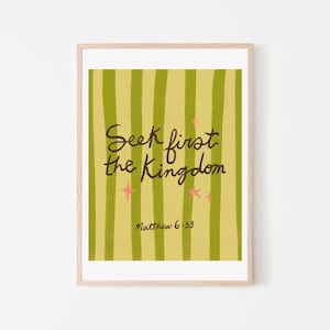 May include: A framed art print with the text "Seek first the Kingdom" in black script. The background features vertical green stripes on a yellow-green field, with pink star accents. The text "Matthew 6:33" is below the main text.