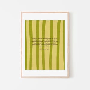 May include: A framed print with a light wood frame. The artwork features a yellow-green background with vertical stripes of a darker green. Text from Philippians 4:6-7 is printed on the artwork.