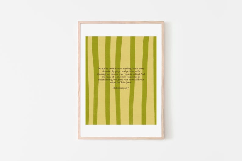 May include: A framed print with a light wood frame. The artwork features a yellow-green background with vertical stripes of a darker green. Text from Philippians 4:6-7 is printed on the artwork.