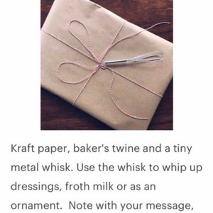 May include: A brown paper package tied with baker's twine and a small metal whisk. The package is tied with a bow and the whisk is placed on top of the bow. The text "select "gift wrap" at checkout only &pound;4" is visible at the bottom of the image.