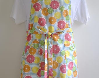 May include: A blue and white striped apron with a citrus fruit print. The apron has two pockets and a tie at the waist.