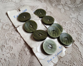 Nine vintage, 1960s, green coat buttons on original card.