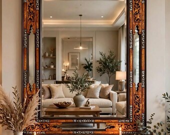 May include: A large rectangular wall mirror featuring an ornate, dark brown wooden frame with intricate carved patterns and metallic silver accents. The frame has a deep, layered structure with geometric cutouts and detailed scrollwork throughout.
