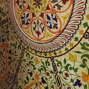 K&ouml;nnte beinhalten: Eine Nahaufnahme einer Decke, die mit einem farbenfrohen Blumenmuster bemalt ist. Das Design weist komplizierte Details und eine Vielzahl von Farben auf, darunter Rot, Gelb, Gr&uuml;n und Blau.