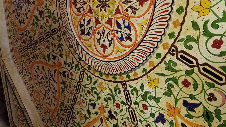 K&ouml;nnte beinhalten: Eine Nahaufnahme einer Decke, die mit einem farbenfrohen Blumenmuster bemalt ist. Das Design weist komplizierte Details und eine Vielzahl von Farben auf, darunter Rot, Gelb, Gr&uuml;n und Blau.