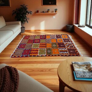 May include: A colorful, patterned area rug with a patchwork design. The rug features squares in shades of red, orange, green, and purple. The rug is placed on a hardwood floor in a living room setting.