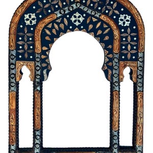 May include: An arched wall mirror frame featuring intricate inlay work with dark blue and light brown wood panels. The design includes repeating floral motifs, geometric patterns, and small white circular accents throughout the structure.