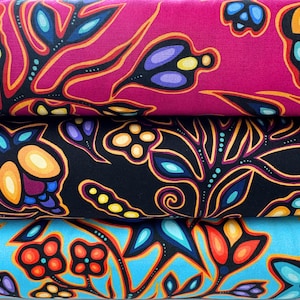 May include: Close-up of three fabric rolls with vibrant floral patterns. The top roll is magenta, the middle is black, and the bottom is turquoise. Each fabric features stylized flowers in orange, yellow, blue, and purple.