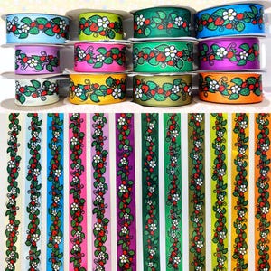 May include: Assortment of 12 rolls of colourful satin ribbon with a repeating pattern of green vines, white flowers, and red strawberries.