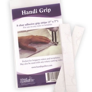 May include: Pack of 8 clear adhesive grip strips, each measuring 2.5 cm by 17.8 cm. The pack is labelled "Handi Grip" and includes instructions for use on rulers and templates. The brand name "Handi Gadgets" is printed on the pack.
