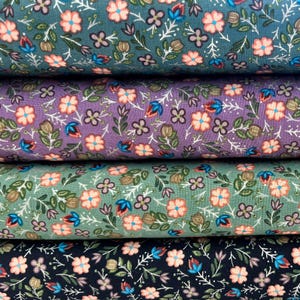 May include: Four rolls of fabric featuring a floral pattern. The fabric comes in four different colours: teal, purple, green, and black. The floral pattern is small and delicate, with pink flowers and green leaves.