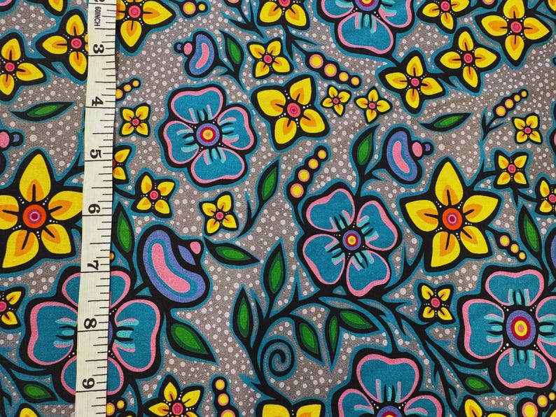 May include: Fabric with a floral pattern featuring large teal and yellow flowers with pink and purple accents on a gray background. The design includes green leaves and stems, with a dotted texture.