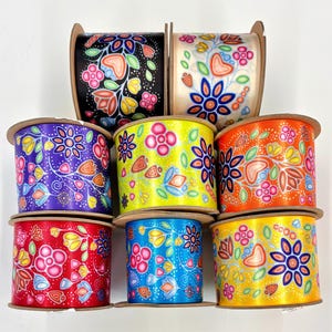 May include: Eight spools of colourful satin ribbon with a floral pattern. The ribbon is in various colours, including red, blue, yellow, orange, purple, and green. The floral pattern is a stylised design with flowers, leaves, and vines.